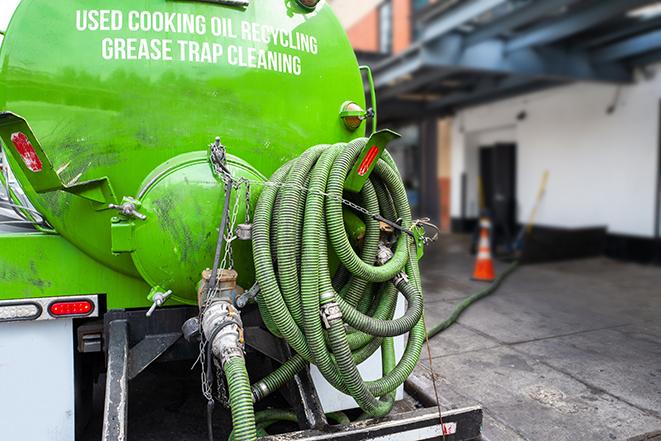 a professional service truck pumping a grease trap in Astor, FL